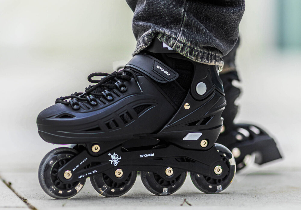Łyżworolki SPOKEY 4ONE 4w1 (rozmiar 39-42) Czarny chodnik osoba w łyżworolkach zbliżenie na stopy całoroczna aktywność do jazdy latem i zimą aktywne spędzanie czasu hobby pasja