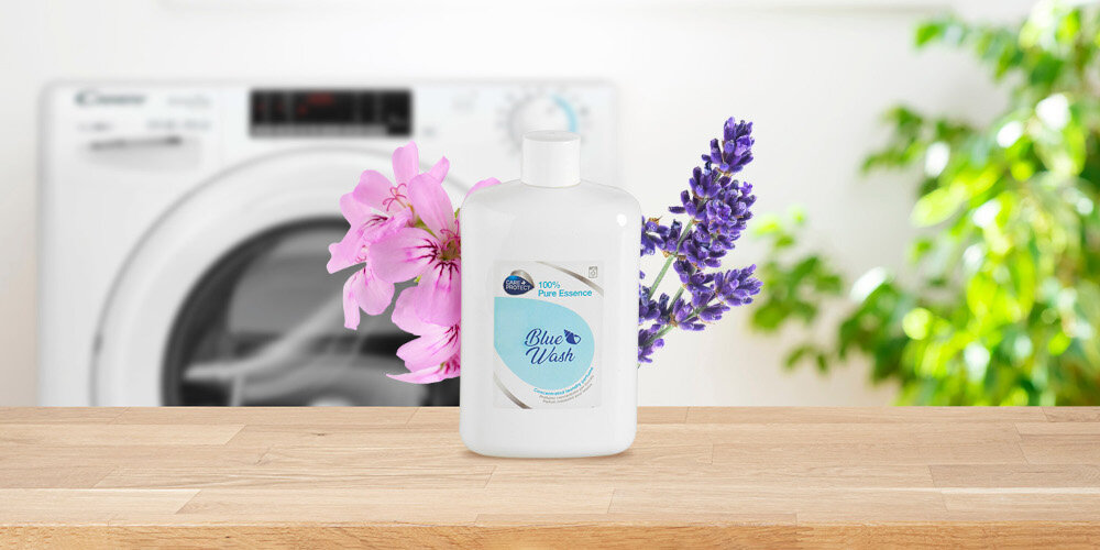 PERFUMY DO PRALKI CARE+PROTECT zdjęcie lifestyle butelka kwiaty pralka w tle zieleń roślina świeżość igieł sosnowych subtelna kwiatowa nuta cyklamenu lawenda goździki geranium drzewa cedr bursztyn kumaryna