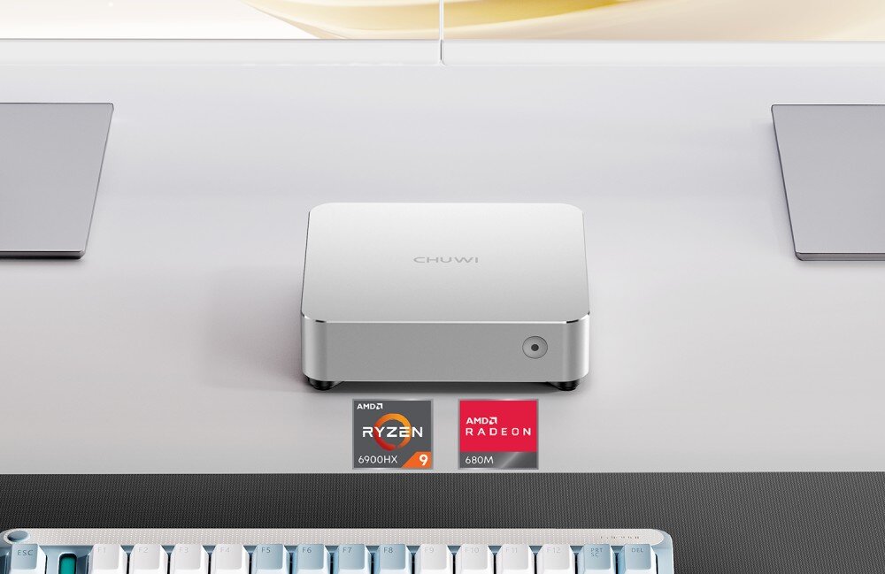 Komputer CHUWI AuBox-P Miniaturowy komputer o metalicznej obudowie umieszczony na biurku, a poniżej logo procesora AMD Ryzen 9 6900HX oraz grafiki Radeon 680M, opis