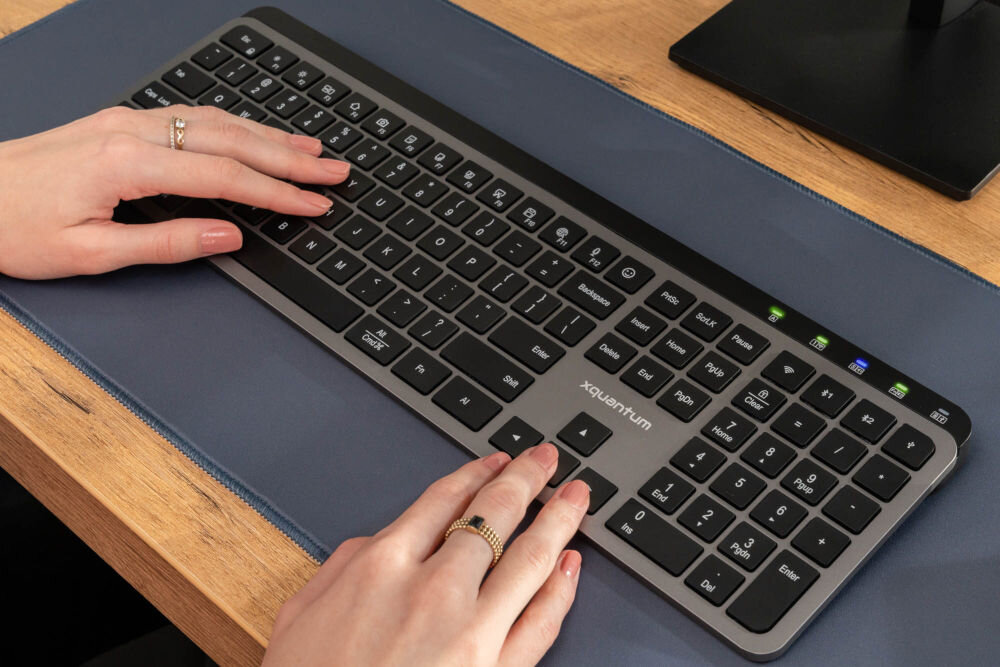 KLAWIATURA XQUANTUM WK500K Wireless dłonie położone na klawiaturze zdjęcie pod kątem pełnowymiarowa klawiatura bezprzewodowa z trzema interfejsami łączności