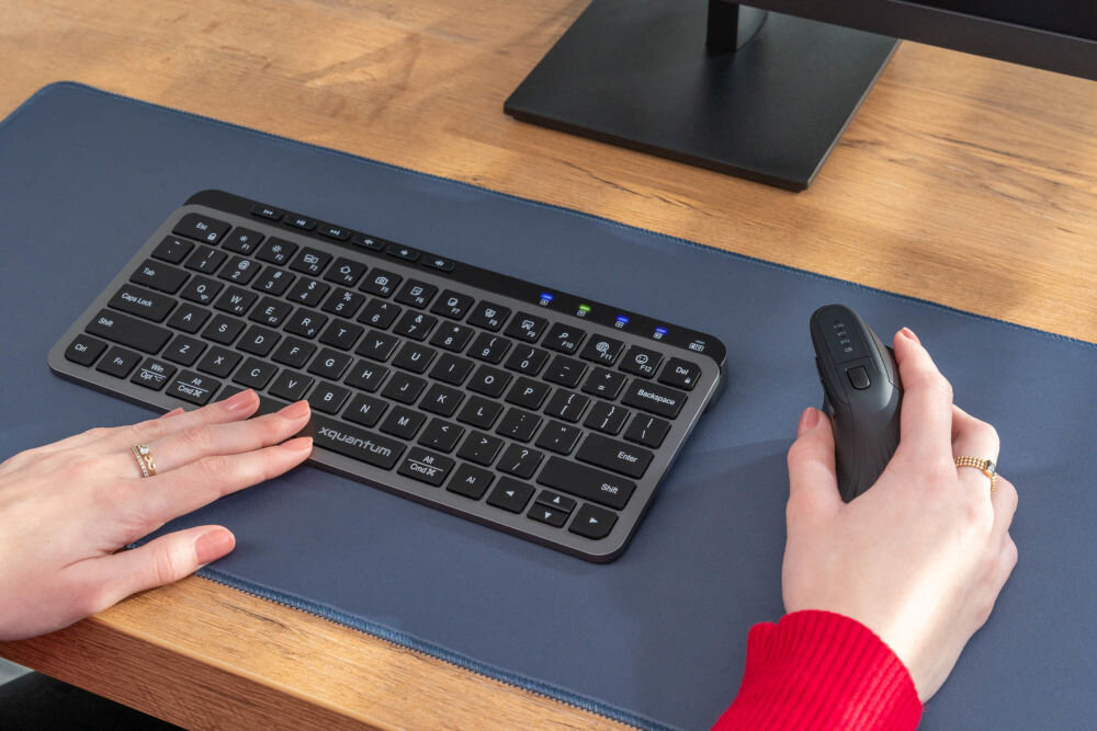 Klawiatura XQUANTUM WK510K Wireless dłonie położone na klawiaturze i myszce zdjęcie pod kątem klawiatura bezprzewodowa z trzema interfejsami łączności
