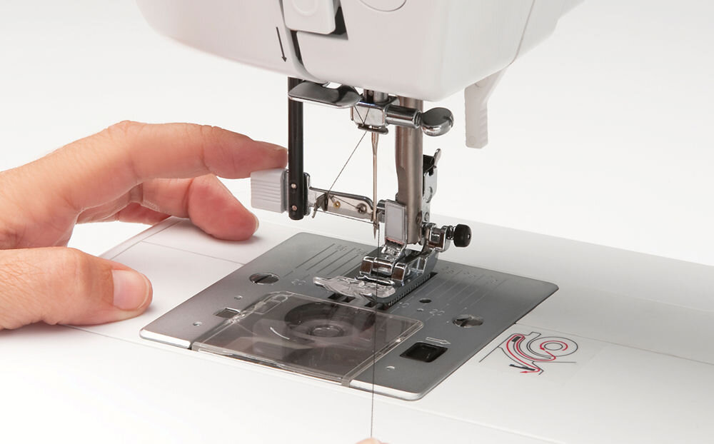 Hafciarka BERNETTE B79 + Program Bernina Creator V9 maszyna zbliżenie na stopkę przyciski osoba trzyma nitkę Szybki i intuicyjny nawlekacz igły przygotowanie maszyny do pracy ułatwienie procesu szycia oszczędność czasu uniknięcie frustracji wygoda komfort użytkowania