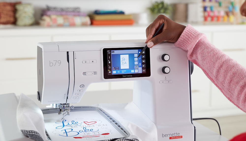 Hafciarka BERNETTE B79 + Program Bernina Creator V9 osoba trzyma rysik zaznacza funkcję na ekranie pokrętła szycie haftowanie Dotykowy ekran 5” HD z szerokim kątem widzenia (180°) wygodna intuicyjna obsługa przejrzysty interfejs wybranie ściegu wzoru haftu ustawienia dostosowanie urządzenia płynna łatwa praca komfort precyzja