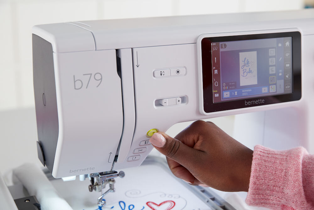 Hafciarka BERNETTE B79 + Program Bernina Creator V9 maszyna wyświetlacz pokrętła osoba wciska żółty przycisk funkcja automatycznego obcinania nici naciśnięcie przycisku przycięcie górnej i dolnej nici przyspieszenie pracy zwiększona wygoda płynne przejście do kolejnych etapów szycia