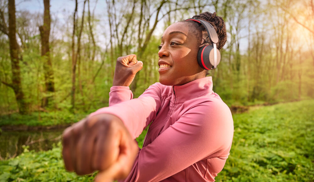 Słuchawki nauszne PHILIPS TAA6219BK/00 światło moc działanie zasilanie słoneczne, osoba z założonymi słuchawkami nausznymi podczas treningu na świeżym powietrzu
