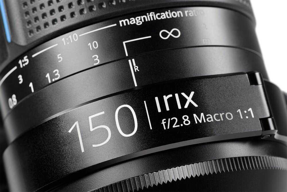 Zbliżenie na obiektyw z widocznymi oznaczeniami: \'magnification ratio\', \'150\', \'Irix\', \'f/2.8 Macro 1:1\'.