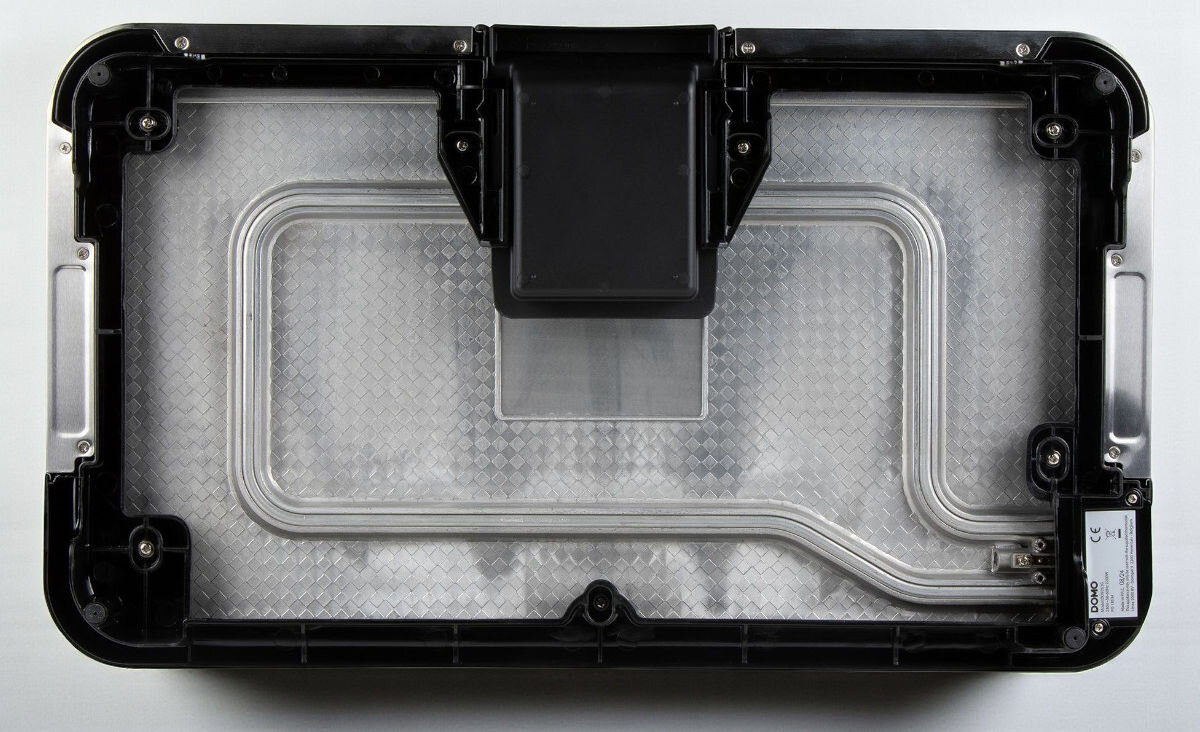 Grill DOMO Plancha XXL DO9263G, równomierne ciepło, szybkie nagrzewanie, grill aluminiowy, soczyste potrawy, Widok od spodu na planchę DOMO DO9263G, pokazany element grzewczy zatopiony w aluminiowej płycie, centralna tacka