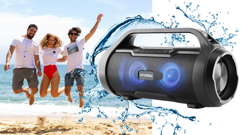 Głośnik mobilny HYUNDAI BTS40B wodoodporność IPX5 40W basy przetworniki panel sterowania, osoby bawiące się na plaży, głośnik po skosie otoczony wodą
