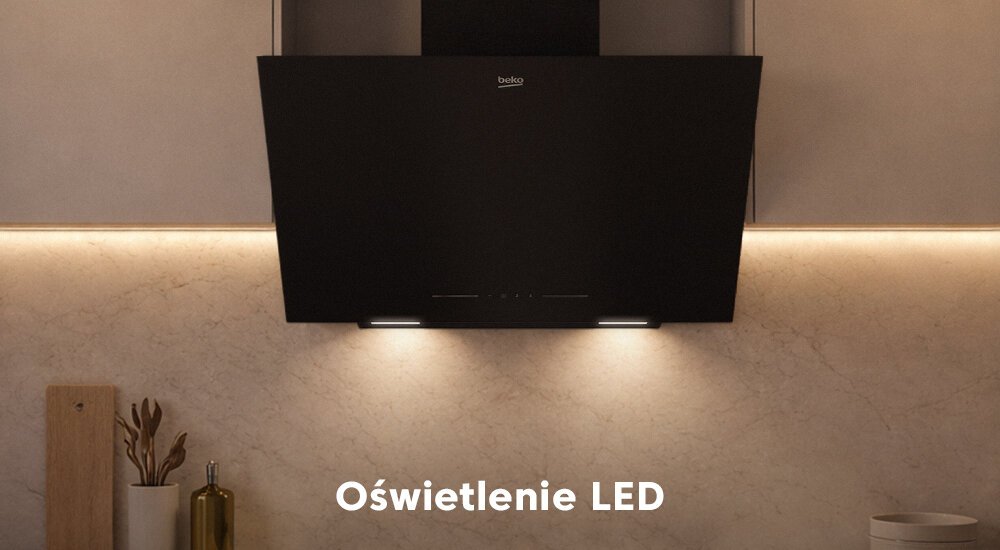OKAP BEKO BHCA62442BBHF W stylowej kuchni pokazano czarny okap BEKO z włączonymi światłami, które oświetlają blat i ścianę wykończoną jasnym kamieniem. U dołu zdjęcia widnieje napis „Oświetlenie LED” oświetlenie LED energooszczędność równomierne światło komfort gotowania