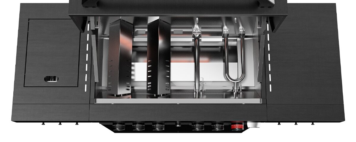 Obraz przedstawia wnętrze grilla gazowego z widocznymi palnikami i elementami konstrukcyjnymi. Grill ma metaliczną obudowę i kilka pokręteł na dolnym panelu.