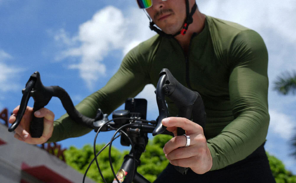 Smartring RINGCONN Gen 2 osoba jadąca na rowerze z pierścieniem na palcu wytrzymały tytan trening liczenie kroków spalone kalorie