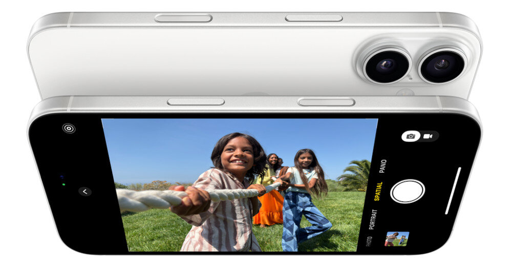 Dwa smartfony z widocznymi aparatami fotograficznymi i ekranem, na którym widać dzieci bawiące się na trawie. Na ekranie widoczne są ikony aparatu, trybu portretowego i panoramy.