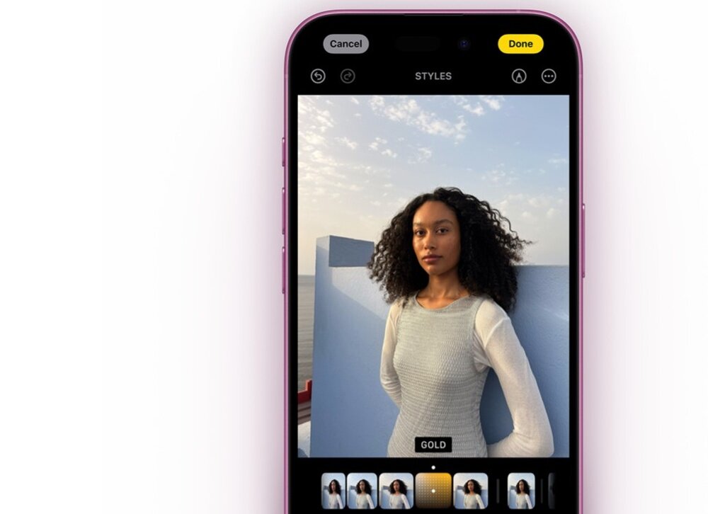 Smartfon z różową obudową wyświetla zdjęcie kobiety na ekranie w aplikacji aparatu. Na ekranie widoczne są przyciski \'Cancel\', \'Done\' oraz opcje stylów z zaznaczoną opcją \'GOLD\'.