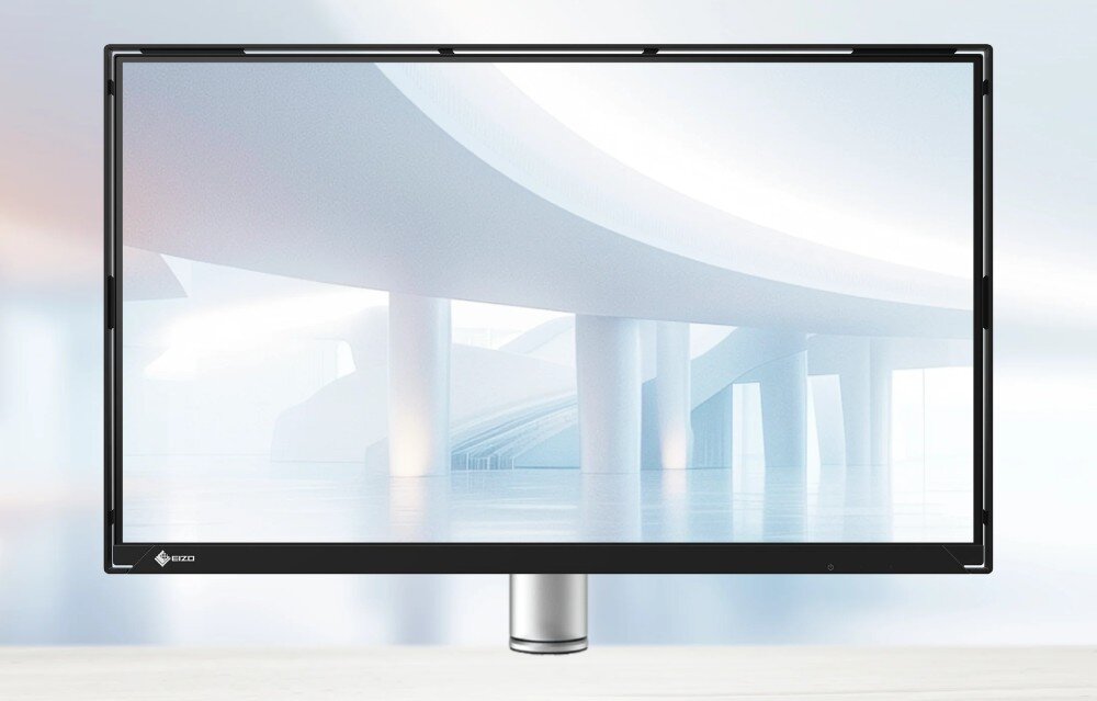 Monitor EIZO FlexScan FLT-BK Widok na monitor stojący centralnie na białym biurku. Na ekranie widoczna grafika przedstawiająca futurystyczne, jasne wnętrze z łukowymi konstrukcjami, konstrukcja, wygląd