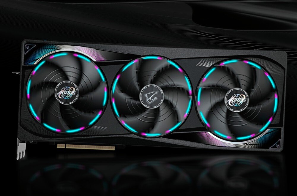 Karta graficzna GIGABYTE Aorus GeForce RTX 5090 Master 32GB Widok karty graficznej od przodu, prezentujący trzy wentylatory z pierścieniowym podświetleniem LED w kolorach niebieskim i różowym na czarnym tle, system chłodzenia, wentylatory, łopatki