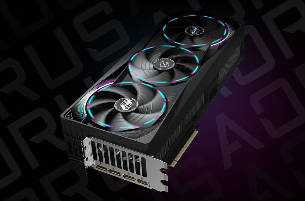 Karta graficzna GIGABYTE Aorus GeForce RTX 5090 Master 32GB Perspektywiczny widok karty graficznej z trzema dużymi wentylatorami, złącza wideo widoczne na dolnej krawędzi, złącza, monitory, podłączenie, złącze zasilania