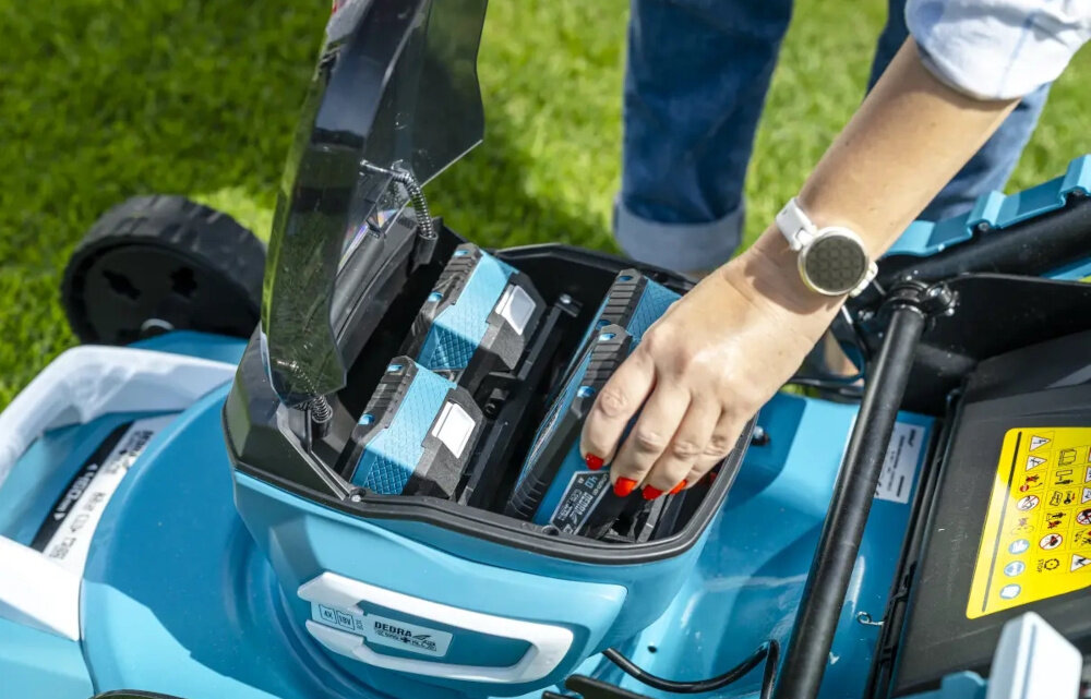 Kosiarka akumulatorowa DEDRA DED6998X z napędem ogród trawnik osoba wyciąga akumulator z wnętrza kosiarki kompatybilna z akumulatorami z uniwersalnej serii DEDRA SAS+ALL wymaga dwóch akumulatorów do pracy brak akumulatorów w zestawie praca od 24 minut na akumulatorze o pojemności 4 Ah do nawet 48 minut z akumulatorem 8 Ah