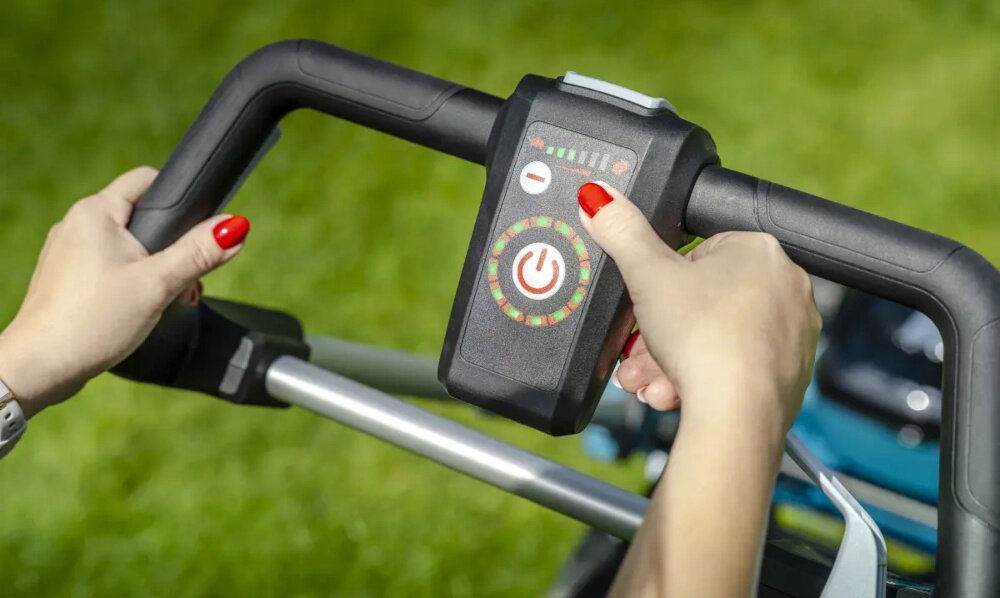 Kosiarka akumulatorowa DEDRA DED6998X-2A5-2A5 z napędem trawnik ogród zbliżenie na reduktor osoba trzyma palec na przycisku silnik bezszczotkowy z reduktorem GT (General Transmission) dłuższa żywotność i maksymalna efektywność energetyczna pracuje ciszej z mniejszymi stratami energii wyższa kultura pracy reduktor GT optymalizuje przenoszenie mocy prędkość obrotowa na poziomie 2800–3200 RPM kluczyk bezpieczeństwa