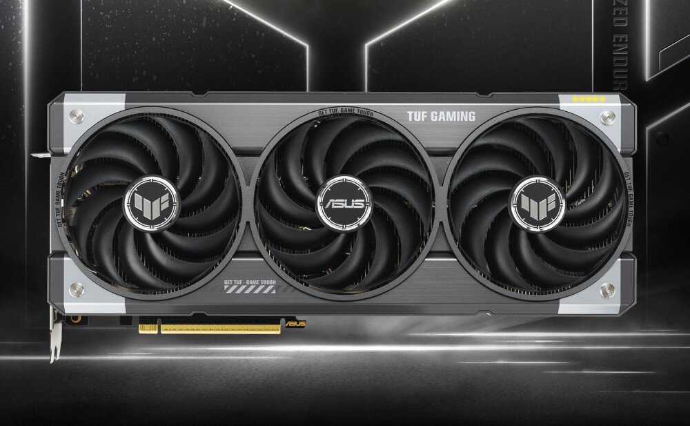 Karta graficzna ASUS TUF Gaming Radeon RX 9070 XT OC 16GB Widok z przodu karty graficznej z trzema dużymi wentylatorami. Na środku znajduje się logo ASUS, a po bokach widoczne są logotypy serii TUF Gaming, opis
