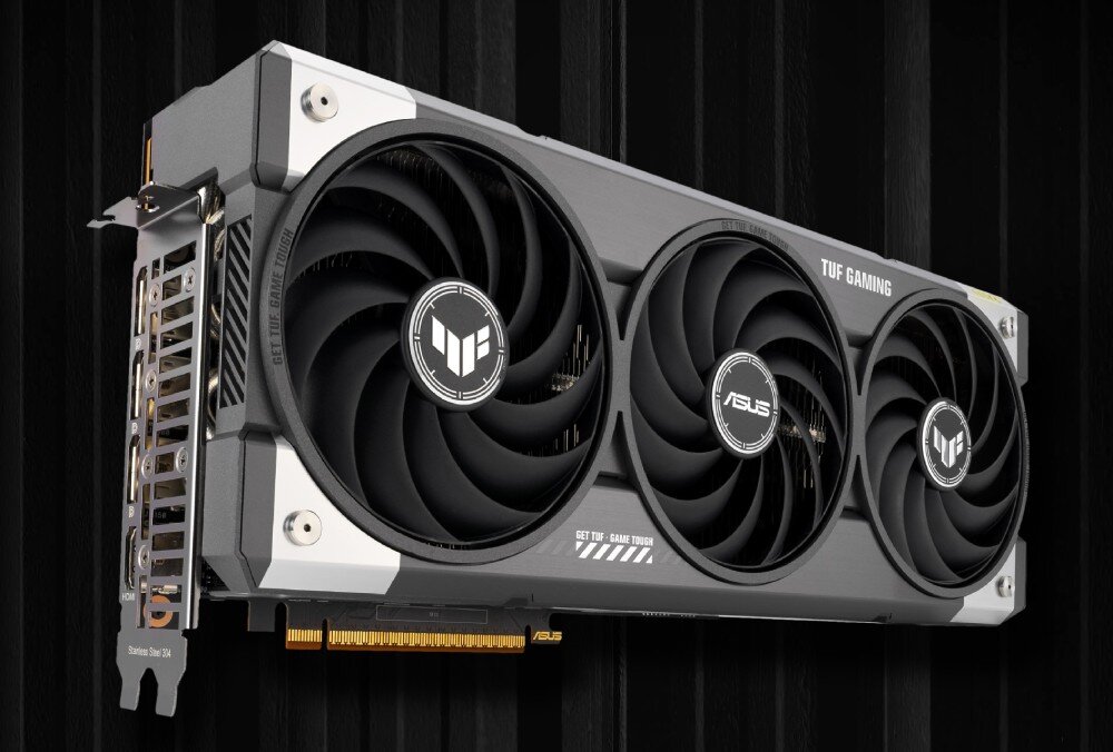 Karta graficzna ASUS TUF Gaming Radeon RX 9070 XT OC 16GB Widok karty graficznej pod lekkim kątem. Trzy wentylatory umieszczone na froncie, z lewej strony widoczne są złącza wideo i konstrukcja chłodzenia, architektura, śledzenie promieni, sztuczna inteligencja, funkcje