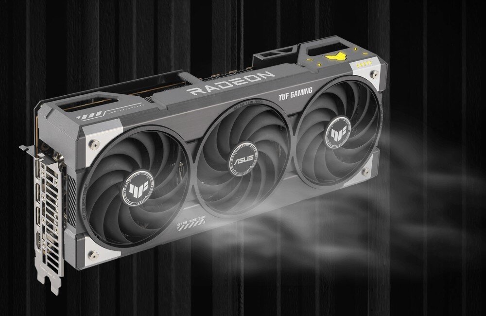 Karta graficzna ASUS TUF Gaming Radeon RX 9070 XT OC 16GB Perspektywiczny widok karty graficznej, z której wydobywa się mgiełka symbolizująca przepływ powietrza. Widoczne trzy wentylatory oraz napis 'RADEON' na górze obudowy, wentylatory, chłodzenie, wentylacja, termopady