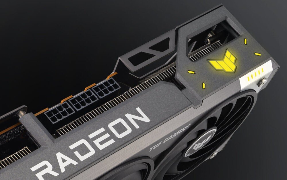 Karta graficzna ASUS TUF Gaming Radeon RX 9070 XT OC 16GB Górna część karty graficznej z podświetlanym logiem TUF i widocznymi złączami zasilania PCIe, interfejs, procesory Ryzen, pamięć