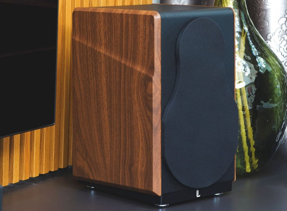 Kolumny głośnikowe LAUDBERG M1 DSP optymalizacja dźwięku, kolumna stojąca na szafce obok zawieszonego telewizora oraz wazonu