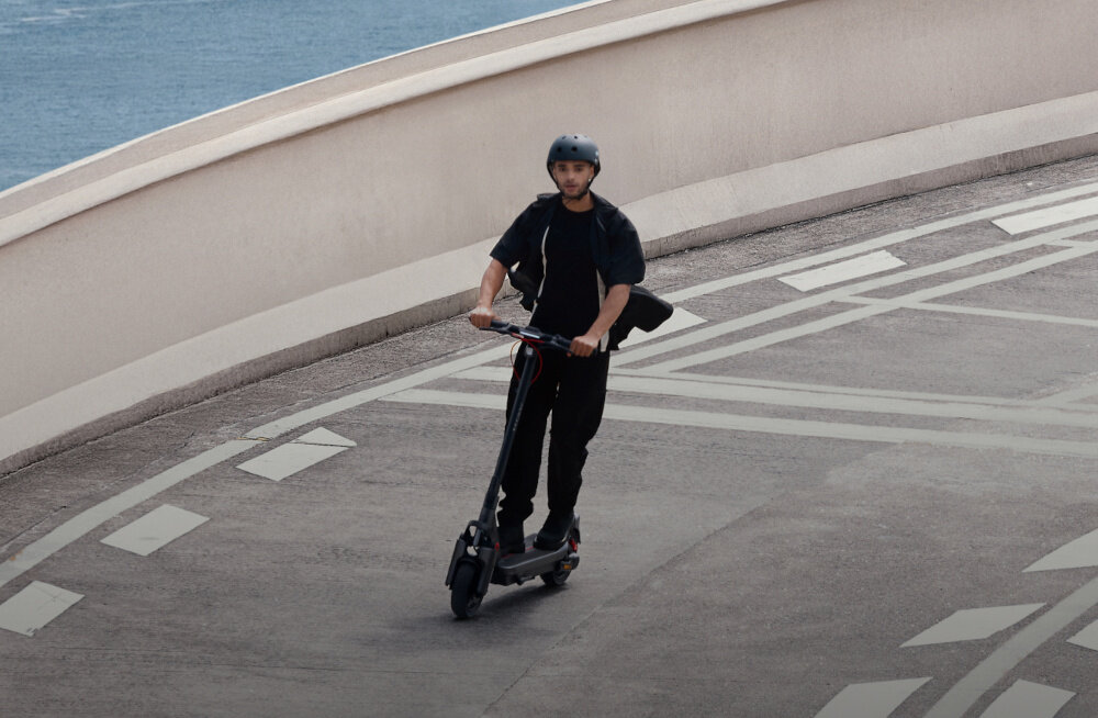 Hulajnoga elektryczna SEGWAY Ninebot Max G3 D 80km 2000W 2 amortyzatory 11 cali Czarny miasto niebo osoba jedzie na hulajnodze po ulicy środek codziennego transportu styl stabilność bezpieczeństwo