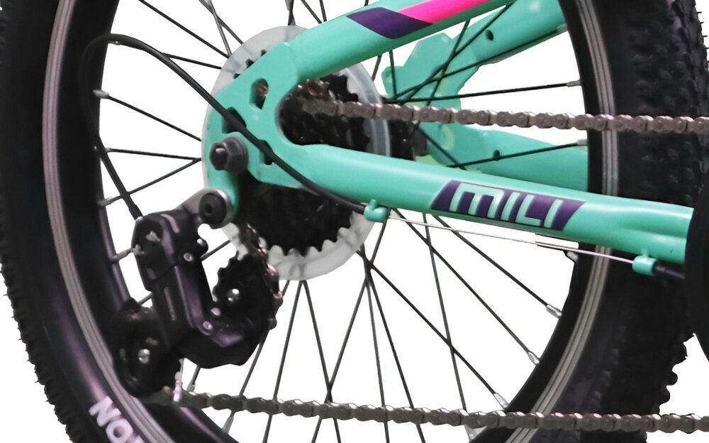 Fragment roweru dziecięcego w kolorze miętowym z widocznym napisem \'MILI\' na ramie. Widać część tylnego koła z oponą i mechanizmem przerzutki.