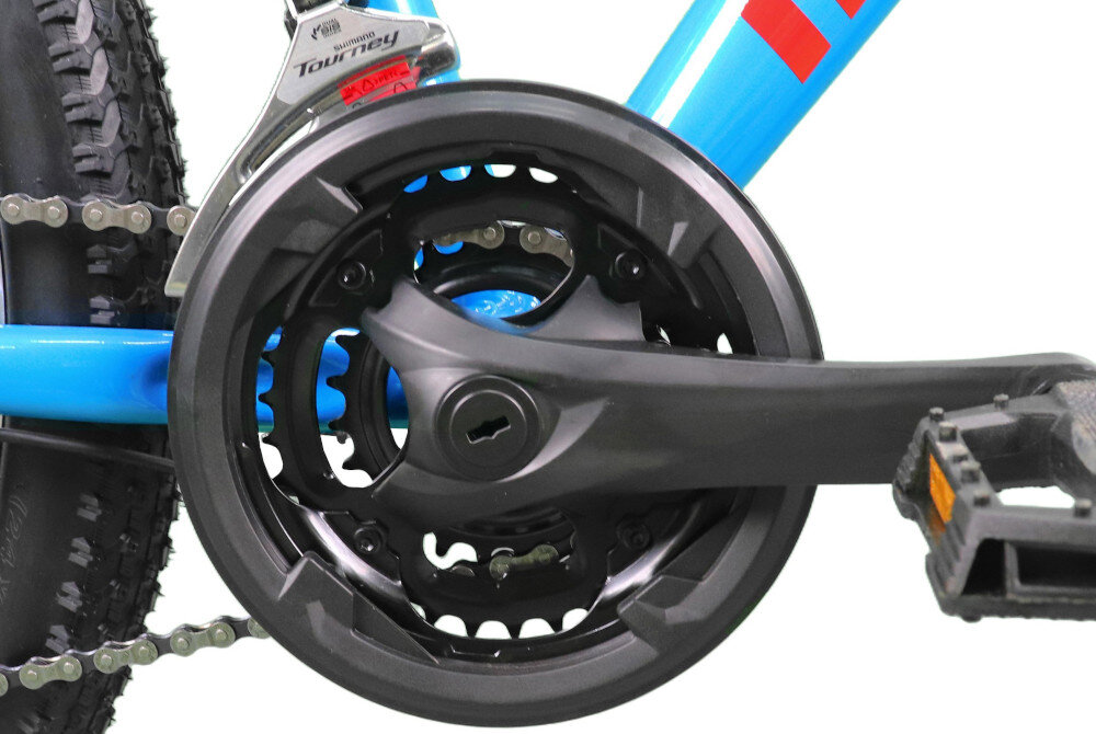 Rower młodzieżowy INDIANA X-Pulser 2.4 24 cale dla chłopca Niebiesko-czerwony zbliżenie na korbę i wolnobieg stalowa wydajna konstrukcja korby marki INDIANA wolnobieg BEST typu 14-28z solidny i wytrzyma obciążenie nawet w trudnych warunkach