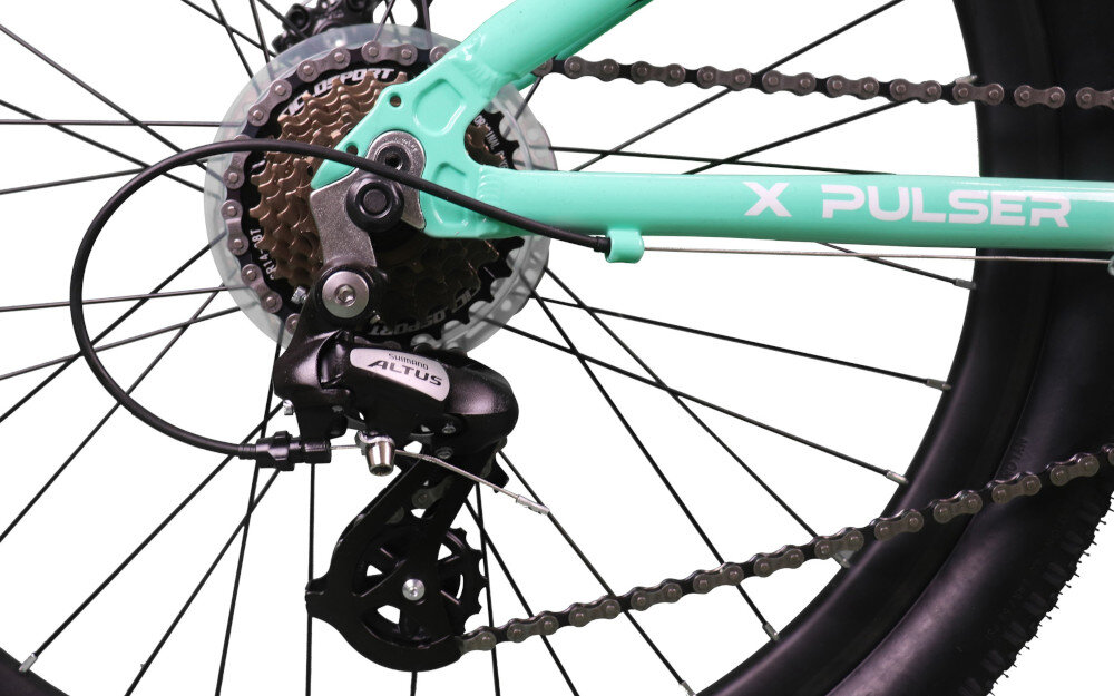 Zbliżenie na tylną część roweru z widocznym mechanizmem przerzutki Shimano Altus oraz fragmentem miętowej ramy z napisem \'X PULSER\'.