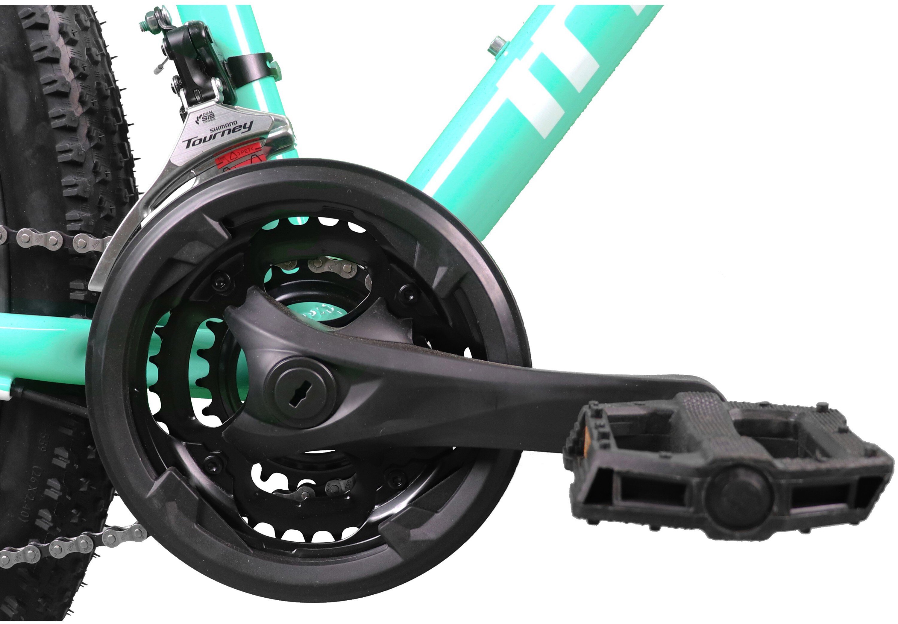 Zbliżenie na mechanizm korbowy roweru z miętowo-białą ramą. Widoczny jest napis \'Tourney\' oraz pedał z czarnym uchwytem.