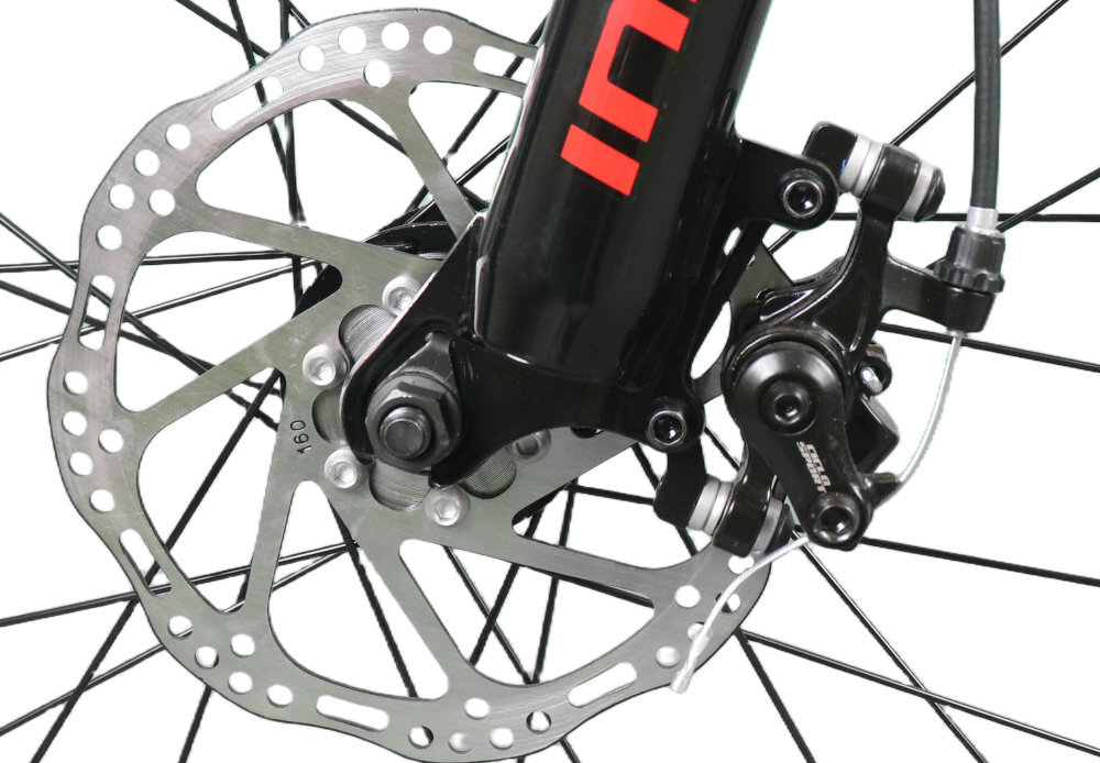 Zbliżenie na tarczę hamulcową roweru z widocznym zaciskiem i fragmentem widelca z napisem \'INDIANA\'.