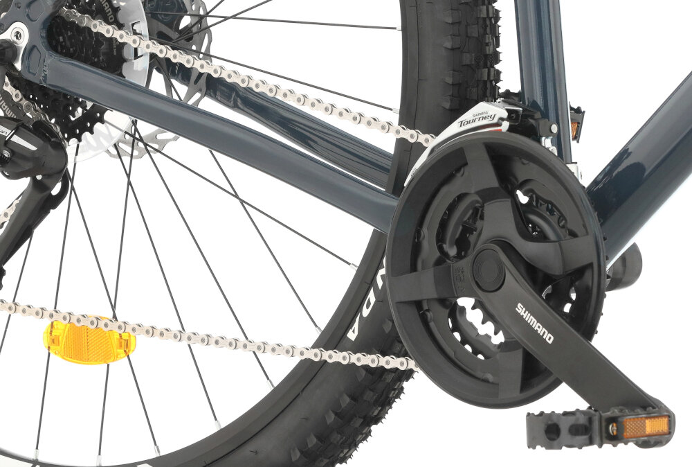 Rower górski MTB INDIANA X-Pulser 2.9 M17 29 cali męski Grafitowo-srebrny zbliżenie na korbę wolnobieg i łańcuch lekka wydajna konstrukcja korby korba SHIMANO typu FC-TY301 kaseta SHIMANO typu CS-HG318134-8S solidność wytrzyma bardzo duży nacisk na pedały