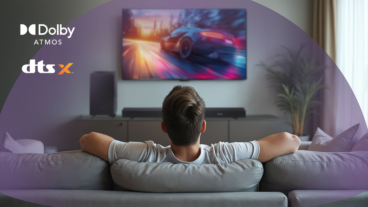 Soundbar SHARP HT-SBW53121 Dolby Atmos DTS:X kinowe efekty, osoba siedząca na kanapie, oglądająca wyścigi samochodowe