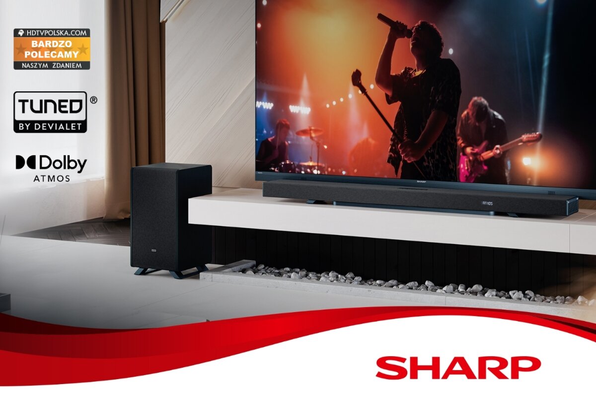 Na obrazie widać telewizor z koncertem na ekranie, soundbar i subwoofer na białej półce. Widoczne są loga: \'TUNED BY DEVIALET\', \'Dolby Atmos\' oraz \'SHARP\'.