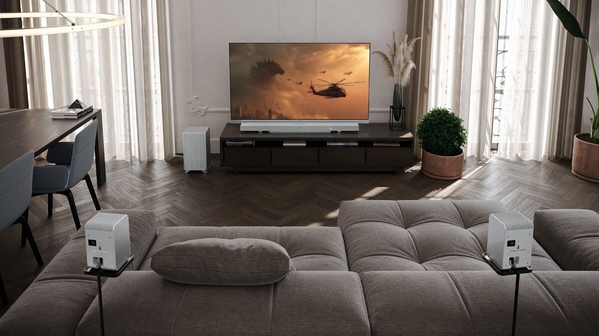 Kolumny głośnikowe SHARP HT-SPR52021 kinowe wrażenia Dolby Atmos DTS:X, głośniki stojące na podstawkachza kanapą skierowane w strone telewizora