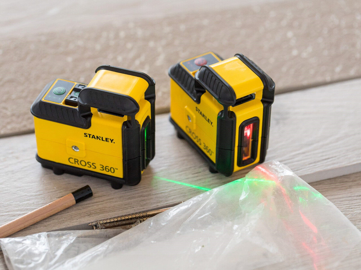 Laser liniowy STANLEY STHT77640-1, czerwona, pozioma, zasięg, samopoziomowanie, 2 lasery stoją na kartonie z włączonymi wiązkami