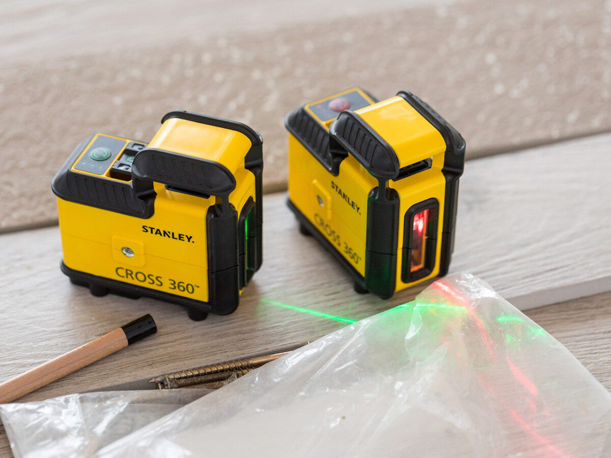 Laser liniowy STANLEY STHT77640-1, czerwona, pozioma, zasięg, samopoziomowanie, 2 lasery stoją na kartonie z włączonymi wiązkami