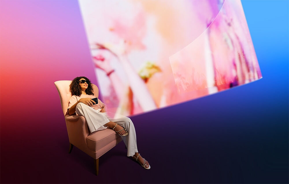 Okulary XREAL One Czarny prezentacja okularów podczas użytkowania przez kobietę siedzącą na fotelu przed nią wirtualny ekran częstotliwość odświeżania naturalny ruch obrazu algorytm stabilizacji ogranicza występowanie zakłóceń