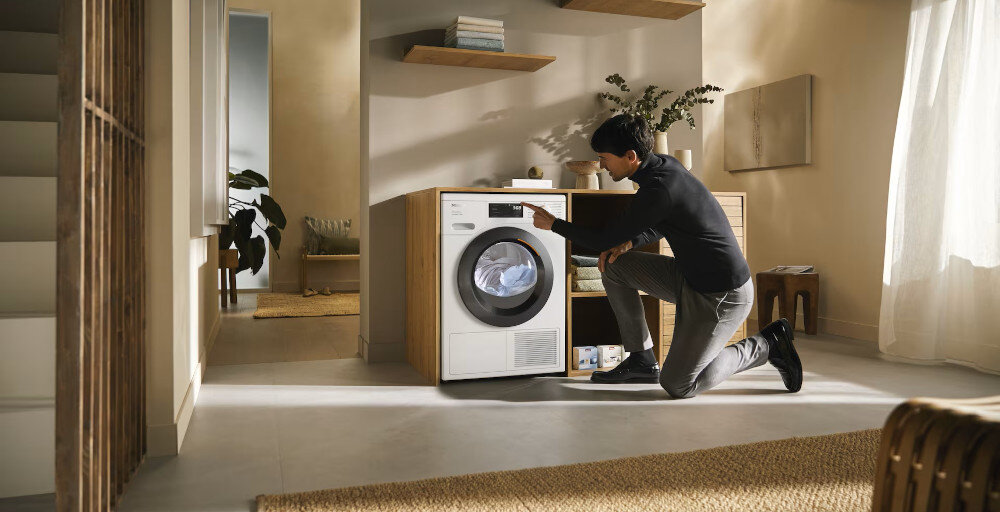 SUSZARKA MIELE TED645 WP wizualizacja kolor biały bok front półki akcesoria dekoracje mężczyzna zmieniający ustawienia na panelu sterowania Testowane na 20 lat użytkowania silnik wydajność Kompleksowo precyzyjnie