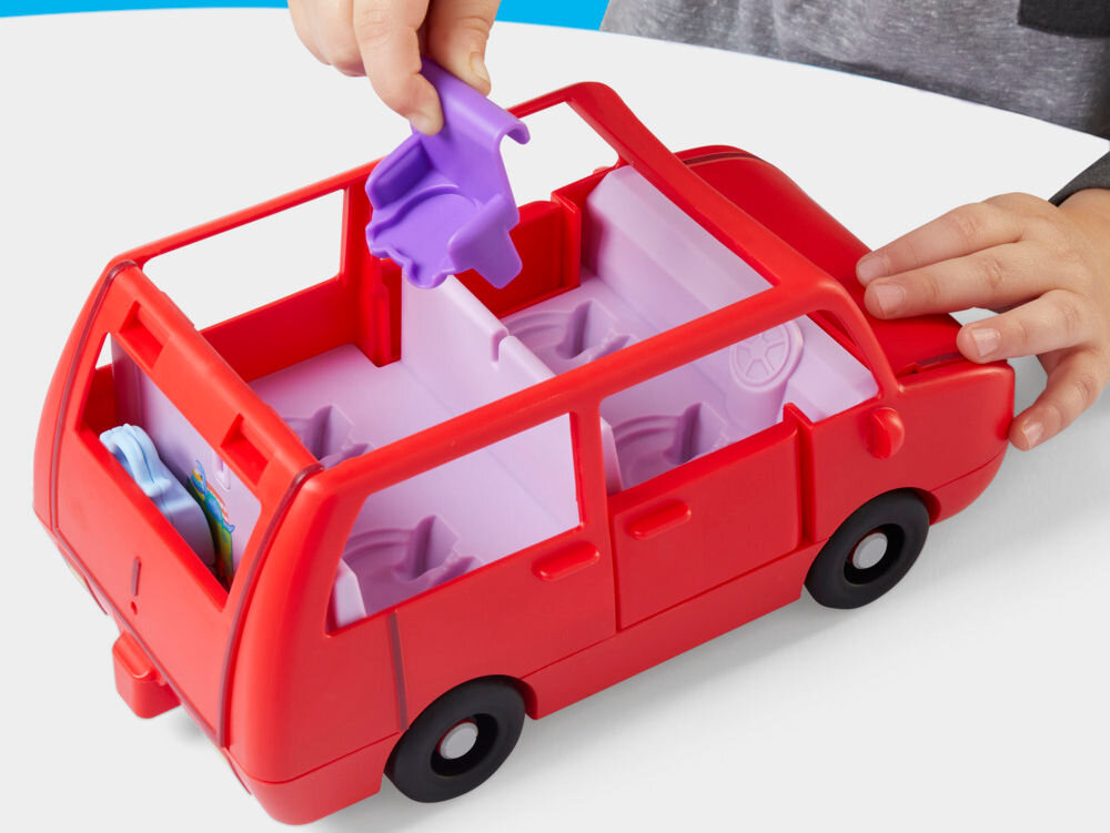 Zestaw figurek HASBRO Świnka Peppa Duży pojazd G05415L0 Zdjęcie z góry na czerwonego zabawkowego vana Peppa Pig, do którego wnętrza dziecko w dżinsowej kurtce wkłada od góry figurkę George'a. Wewnątrz auta, na fioletowych siedzeniach, siedzą już figurki Pani Królik, Peppy i innej świnki. Scena na białym blacie, na tle błękitnego nieba.