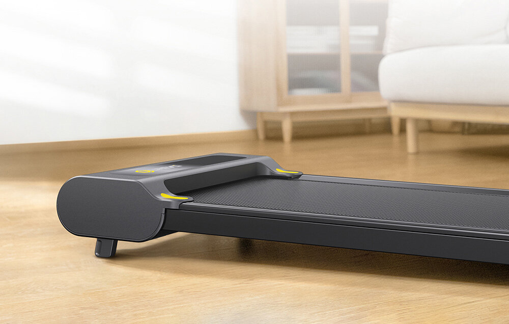 Bieżnia elektryczna UREVO E3S 1654.87W 6.4 km-h Zbliżenie na niskoprofilową bieżnię treningową UREVO stojącą na jasnej podłodze w nowoczesnym pokoju domowa bieżnia elektryczna intuicyjna regulacja kąta nachylenia cicha praca integracja z aplikacjami niewielka konstrukcja o wymiarach 53 x 12.4 x 126.5 cm