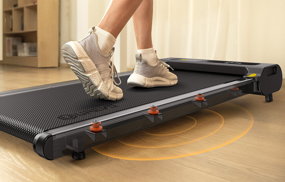 Bieżnia elektryczna UREVO E3S 1654.87W 6.4 km-h Zbliżenie na nogi osoby ćwiczącej na bieżni z widocznym systemem amortyzacji i grafiką rozchodzących się fal pod urządzeniem 8 silikonowych amortyzatorów redukują obciążenie komfort bezpieczeństwo z prędkością od 0,9 do 6,4 km/h