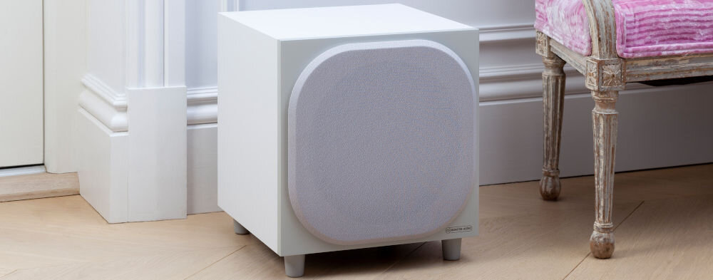Subwoofer MONITOR AUDIO Bronze W10 6G - Wykrywanie sygnału, subwoofer stojący na podłodze obok krzesła