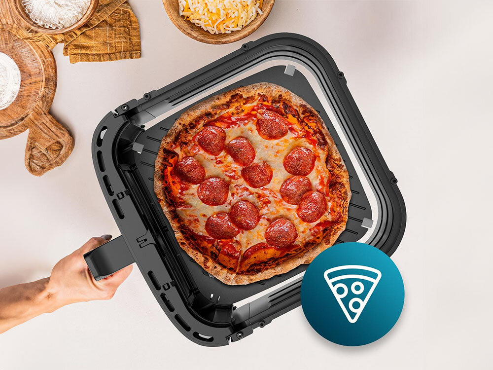 Air Fryer Frytkownica beztłuszczowa CECOTEC Cecofry&Grill Duoheat 8000 osoba trzyma czarny kosz wewnątrz znajduje się pizza jasne tło przygotowywanie pizzy funkcja płyty grzewczej równomiernie wypiekane ciasto optymalny efekt za każdym razem chrupiące brzegi delikatny środek funkcja Pizza Maker prawdziwa włoska pizza