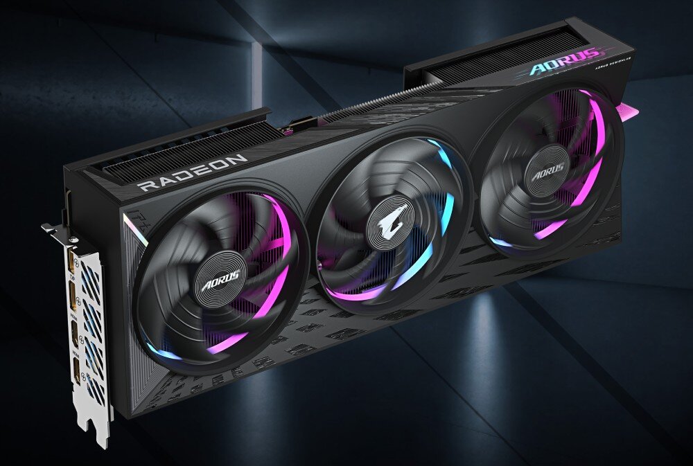 Karta graficzna GIGABYTE Aorus Radeon RX 9070 XT Elite 16GB Trzywentylatorowa karta graficzna z podświetleniem RGB, widoczna z ukosa na tle ciemnej, industrialnej sceny, opis
