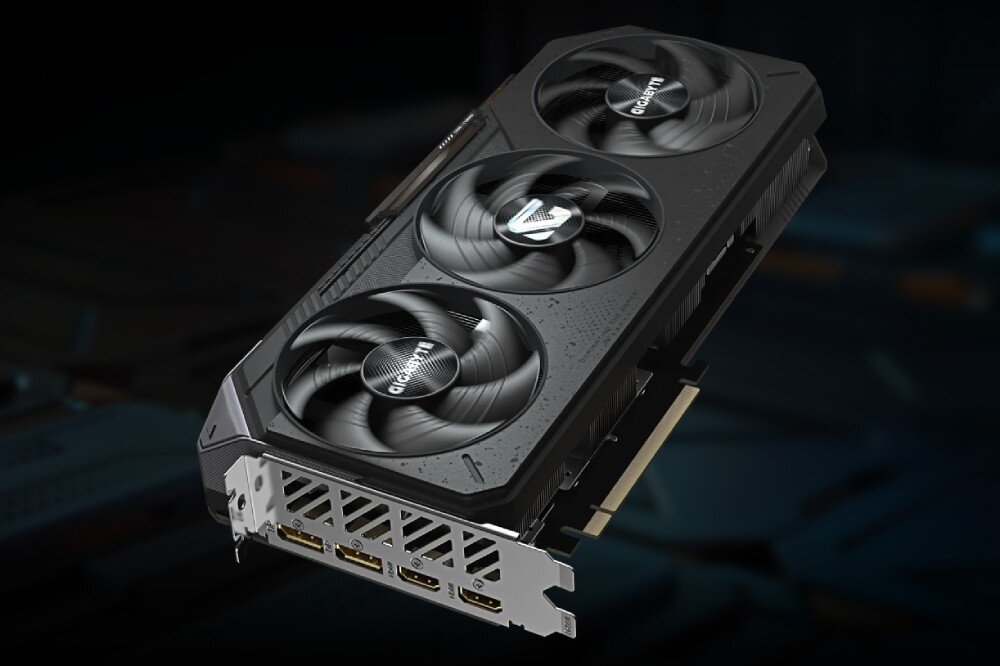 Karta graficzna GIGABYTE Radeon RX 9070 Gaming OC 16GB Karta graficzna z trzema wentylatorami ukazana pod kątem z widocznymi czterema wyjściami wideo w dolnej części, wyjścia, porty, podłączenie