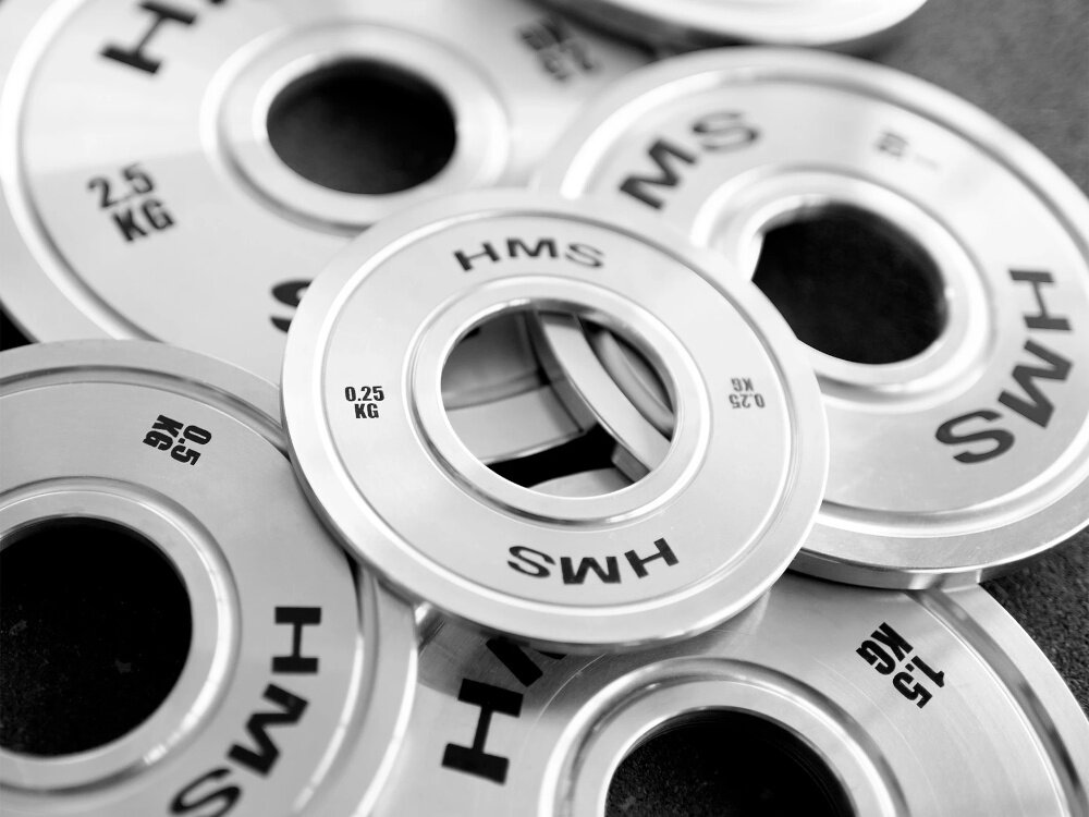 Obciążenie HMS TOS05 (0.25 kg) ciemna podłoga kilka obciążeń ułożonych na sobie z wysokiej jakości stali pokrycie twardym chromem odporność powierzchni na ścieranie, tarcie i działanie czynników zewnętrznych grubsza warstwa chromu chroni przed uszkodzeniami mechanicznymi i korozją