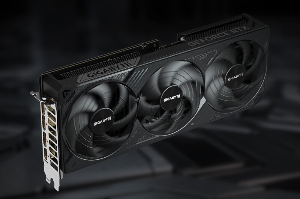 Karta graficzna GIGABYTE GeForce RTX 5080 Windforce SFF 16GB Widok z góry na kartę graficzną z trzema dużymi wentylatorami, widoczne metalowe logo na środku wentylatora, złącza wideo z lewej strony, komponenty, budowa